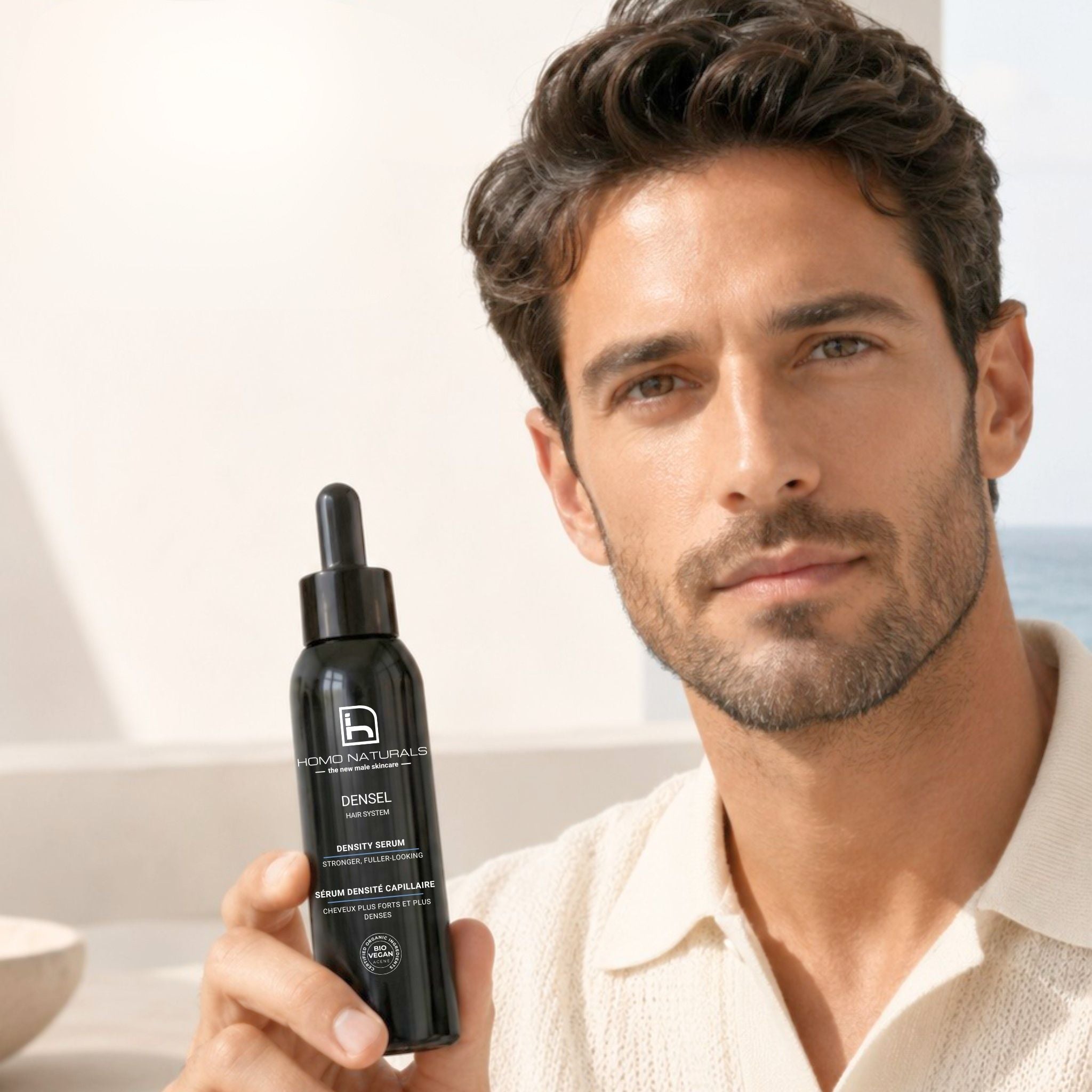 Hombre mostrando DENSEL Hair Serum anticaída para fortalecer el cabello y mejorar la densidad capilar.